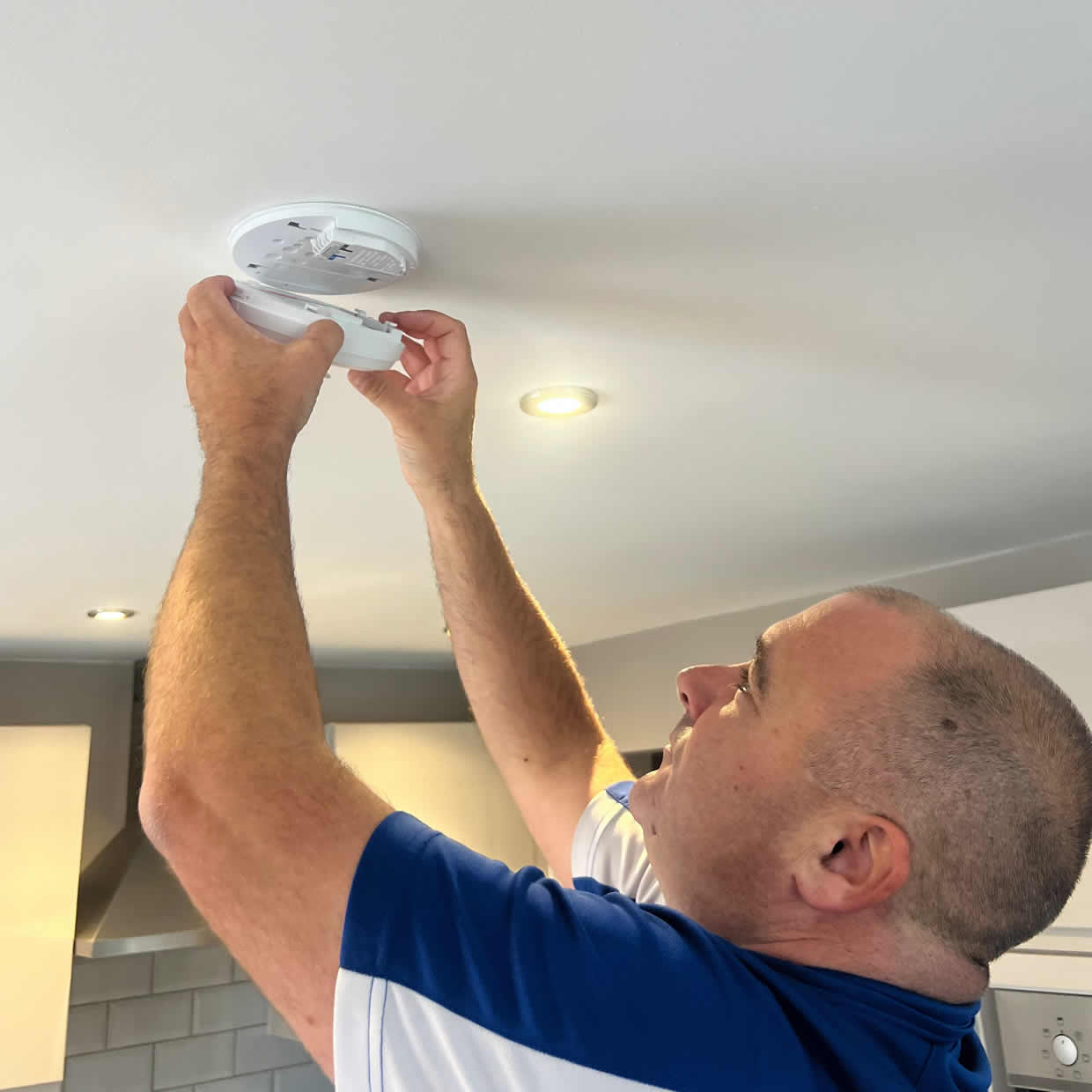Smoke alarm being installed on a ceiling in Stoke-on-Trent